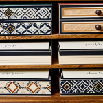**

"A close-up shot of handcrafted card dividers made from patterned cardstock inside a wooden drawer. The dividers are labeled with neat, handwritten categories. Focus on the textures and colors of the cardstock and wood. safe for work, appropriate content, fully clothed, professional, perfect anatomy, natural proportions, high quality."

**