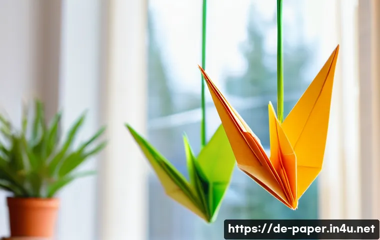 종이 공예로 인테리어 꾸미기 - A vibrant and detailed close-up of a colorful origami mobile hanging near a bright window in a moder...